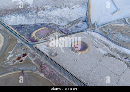 Vue aérienne du lac Searles avec des piscines de saumure rose, des formations de croûte de sel blanche et des étangs d'évaporation circulaires le long des routes industrielles à San Berna Banque D'Images