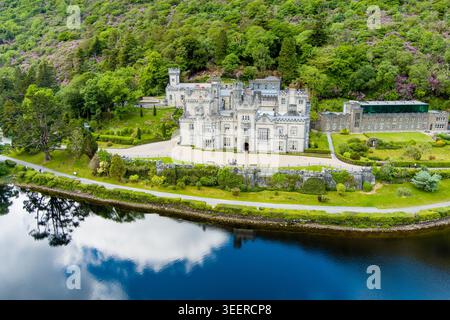 Vue aérienne de l'abbaye de Kylemore à côté de Pollacappul Lough dans le Connemara, comté de Galway, Irlande. Le domaine se trouve entre lac, bois et pente de montagne Banque D'Images