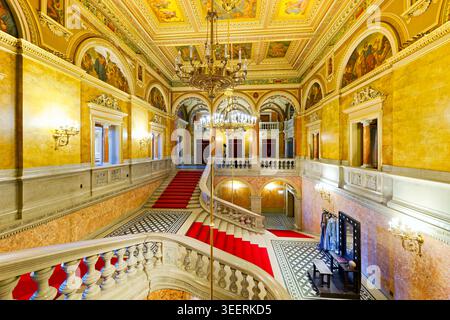 Les visiteurs montent le grand escalier à l'intérieur de l'Opéra national hongrois de Budapest, présentant des décorations ornées et une architecture élégante. Banque D'Images