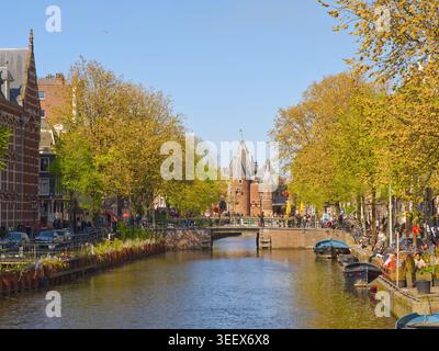 Amsterdam, pays-Bas - 29 avril 2026 : vue panoramique sur le canal à Amsterdam avec architecture historique, bateaux et arbres printaniers bordant la voie navigable Banque D'Images