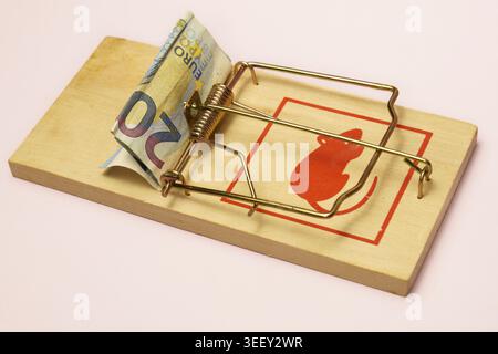 Billet de vingt euros servant d’appât dans un piège à souris traditionnel en bois, symbolisant le risque financier, la dette et la tentation économique Banque D'Images