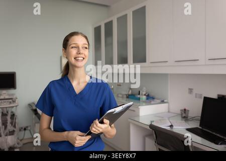 Portrait d'une infirmière dans des gommages médicaux tenant un presse-papiers Banque D'Images