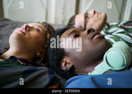 Gros plan sur divers adolescents allongés et relaxants, réfléchissant sur l'amitié, l'identité et le bien-être mental. Utile pour le soutien des jeunes, l'inclusion ou les campagnes de bien-être Banque D'Images