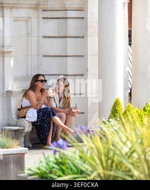 Deux femmes assises ensemble à l'extérieur à Mayfair, Londres pendant l'été. Banque D'Images