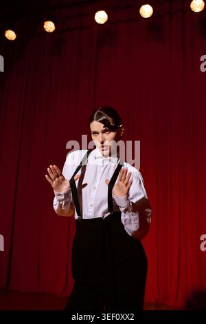 Une jeune et belle femme exprime sa créativité sur scène avec charme et élégance dans un théâtre vibrant. Banque D'Images