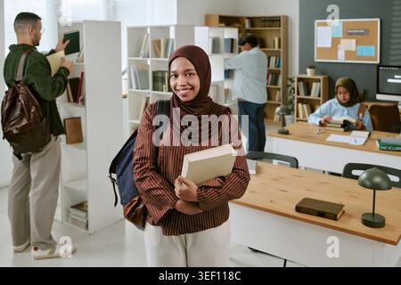 Portrait d'étudiant asiatique étudiant tenant des livres dans la bibliothèque Banque D'Images