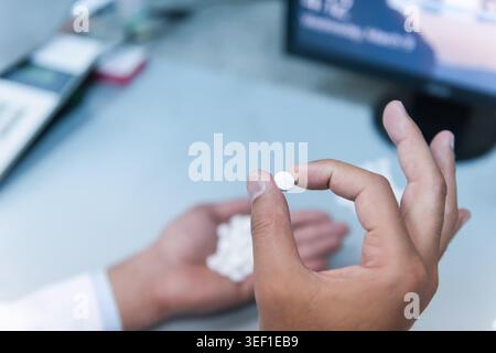 De jeunes techniciens médicaux et médecins du moyen-Orient et du monde arabe travaillent ensemble dans un laboratoire de tests sanguins cliniques, examinant des échantillons et discutant des résultats avec des mains concentrées et du matériel de laboratoire à proximité. Banque D'Images