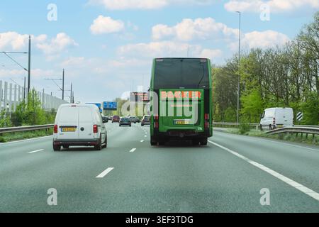 Pays-Bas - 17 avril 2026 : circulation diurne sur une autoroute néerlandaise avec un bus vert Bakker Wormerveer et des fourgonnettes commerciales blanches qui passent sous les yeux Banque D'Images