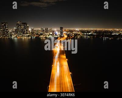 Vue aérienne nocturne de Miami et pont illuminé Banque D'Images
