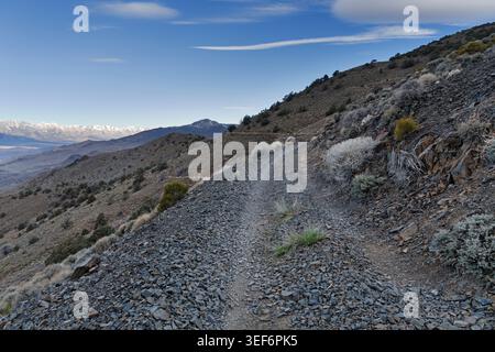 Ancienne route de gravier de Cerro Gordo au tramway de sel de Swansea surplombant la vallée d'Owens avec les montagnes de la Sierra Nevada et la butte de New York sur le hori Banque D'Images