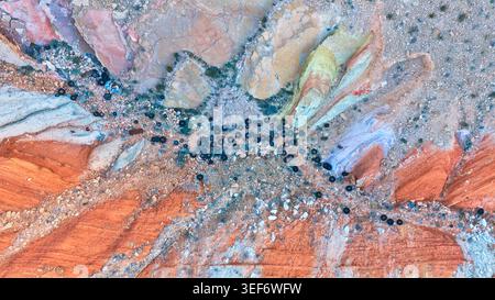 Formations rocheuses aériennes colorées du Nevada et pneus dispersés Top Down Banque D'Images