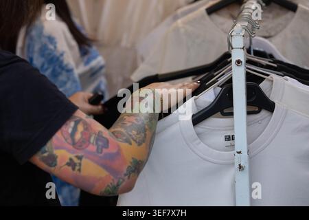 PHAYAO, THAÏLANDE-APR 11, 2026 : femmes mains shopping pour des vêtements dans le marché en plein air, la vie quotidienne dans le marché de rue asiatique, gros plan, Chiang Kham. Banque D'Images