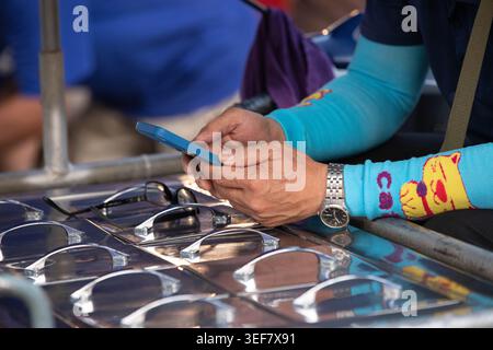 PHAYAO, THAÏLANDE-APR 11, 2026 : fournisseur de produits alimentaires utilisant un smartphone, activité quotidienne sur smartphone, routine urbaine moderne, gros plan, Chiang Kham. Banque D'Images