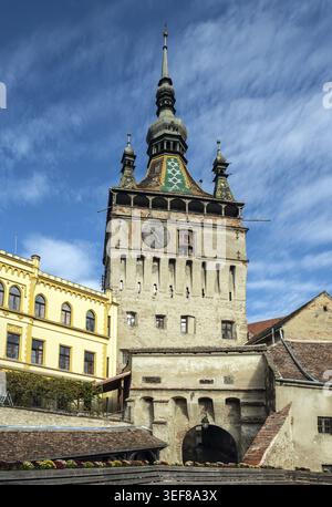 Sighisoara, Roumanie - 21.10.2025. Une vue large de l'emblématique Tour de l'horloge du XIVe siècle avec son toit en tuiles et son horloge astronomique, debout comme la principale Banque D'Images