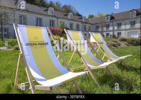 Trois transats en bois jaune et blanc avec le logo du fabricant de champagne Joseph Perrier sur un champ vert devant le siège historique Banque D'Images