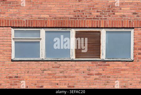 Quatre petites fenêtres sur un ancien bâtiment d'usine Banque D'Images