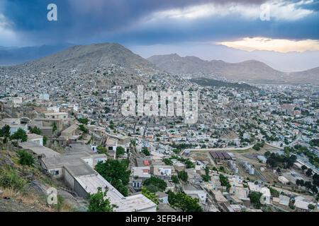 Vue sur le paysage de Kaboul depuis un point de vue avec un mélange de caractéristiques urbaines et naturelles au coucher du soleil Banque D'Images