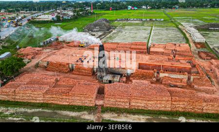 L'usine de briques fonctionne dans la zone rurale avec de la fumée s'élevant de la cheminée à Dhaka Bangladesh Banque D'Images