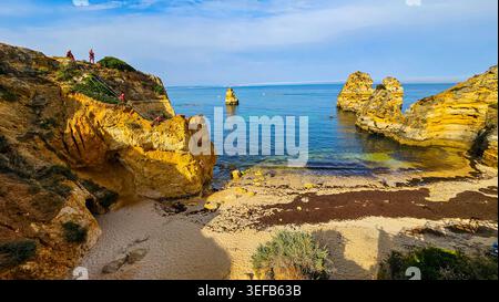 Coucher de soleil sur les falaises de plage en Algarve montrant des formations rocheuses et des eaux claires près de Lagos Banque D'Images