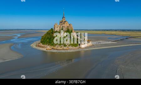 Vue du Mont Michel entouré d'eau à marée basse en France montrant l'architecture historique et le paysage naturel Banque D'Images