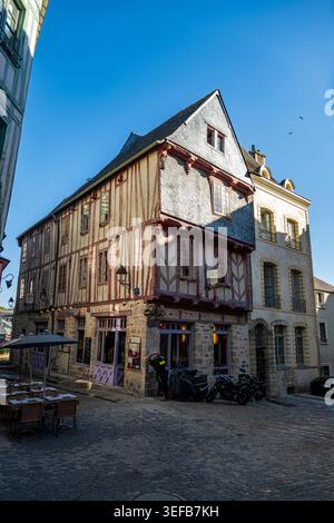 Bâtiment historique avec charpente en bois et coin salon extérieur dans une ville française par une journée ensoleillée Banque D'Images