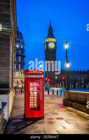 Vue de nuit de Big Ben près d'une cabine téléphonique rouge et des rues de Londres avec des lumières et des bâtiments Banque D'Images