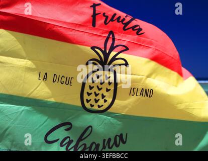 Drapeau agitant sur la plage d'Anse source dArgent montrant l'esprit local et la fierté Banque D'Images