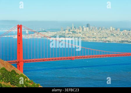 Vue sur le Golden Gate Bridge et le quartier financier de San Francisco avec un ciel bleu clair et des eaux calmes en arrière-plan Banque D'Images