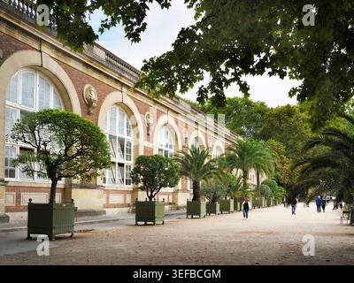 Les visiteurs se promènent le long du sentier près de l'Orangerie entouré d'arbres dans le jardin du Luxembourg à Paris Banque D'Images