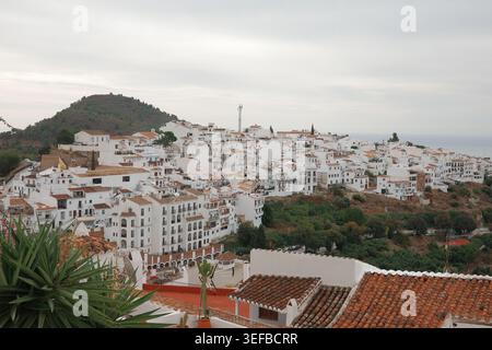 Vue panoramique sur le village de Frigiliana blanchi à la chaux sur les collines avec toits en terre cuite et la mer Méditerranée à l'horizon, Andalousie, Espagne. Banque D'Images