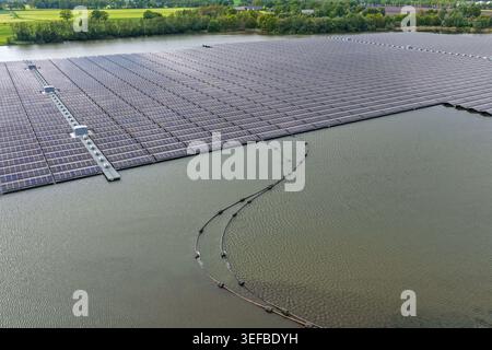 Vue aérienne d'une ferme solaire flottante à grande échelle installée sur une surface de lac calme près de forêts vertes à Beilen, Drenthe, pays-Bas. Banque D'Images