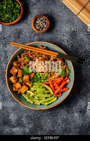 Nouilles soba avec légumes et tofu frit dans un bol. Vue de dessus. Banque D'Images