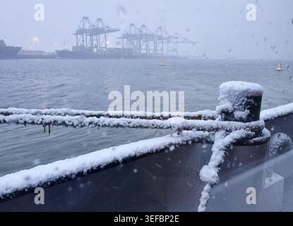 Une corde épaisse est enroulée autour d'une borne sur le côté neigeux d'un navire Banque D'Images