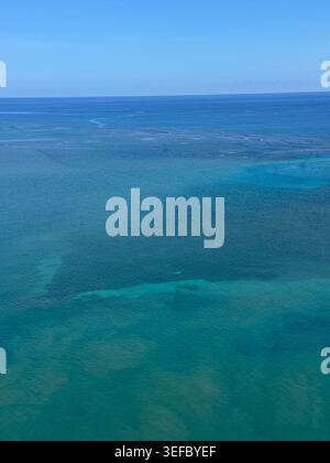 Vue aérienne de dessus de l'eau de mer turquoise cristalline des Caraïbes au-dessus des récifs coralliens en Jamaïque. Banque D'Images