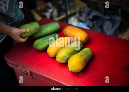 Le marché de fruits local en Thaïlande vend des fruits tropicaux frais mûrs, le client choisissant la papaye sur l'affichage. Banque D'Images