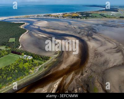Vue aérienne de la baie de Findhorn montrant l'estuaire sablonneux sinueux à marée basse avec le village côtier et la mer bleue au loin Findhorn, Écosse, ONU Banque D'Images