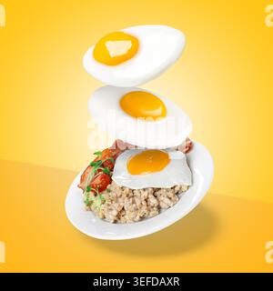 Oeufs frits et assiette de flocons d'avoine cuits volant dans l'air sur fond orange Banque D'Images
