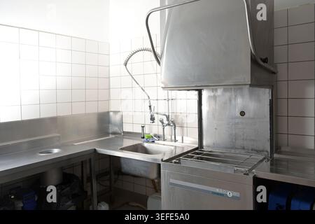 Lave-vaisselle industriel, évier et comptoir professionnel, tous en acier inoxydable, dans une cuisine commerciale d'un restaurant ou d'un service de traiteur, COP Banque D'Images