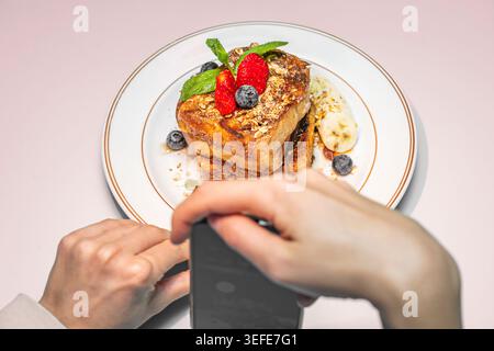 Un gros plan de deux tranches de pain rustique avec une croûte croustillante, surmonté de tomates mûres écrasées, une pincée de sel feuilleté et des lamelles d'ail jetant un coup d'œil Banque D'Images