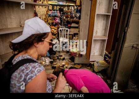 Une femme passe devant un magasin après que des jeunes israéliens de droite l'ont attaqué dans la vieille ville de Wald à Jérusalem, jeudi 14 mai 2026. Des nationalistes israéliens, dont beaucoup d’adolescents et de jeunes adultes, ont balayé les rues étroites de la vieille ville de JerusalemÕs jeudi lors de la marche annuelle de la Journée de Jérusalem, scandant ÒDeath à ArabsÓ et ÒMay vos villages burnÓ alors que des dizaines de milliers de personnes défilaient pour célébrer ce que les autorités israéliennes appellent le ÒreunificationÓ de IsraelÕs Jérusalem après la capture et l’annexion de Jérusalem-est dans la guerre arabo-israélienne de 1967, alors que de nombreux résidents palestiniens restaient l’indo barricadé Banque D'Images