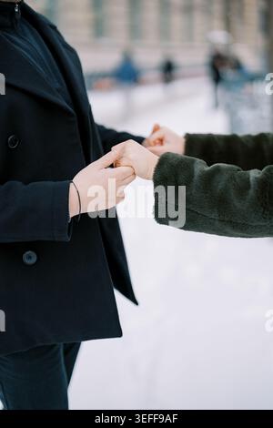 Amis partageant des cadeaux emballés dans un paysage hivernal Banque D'Images