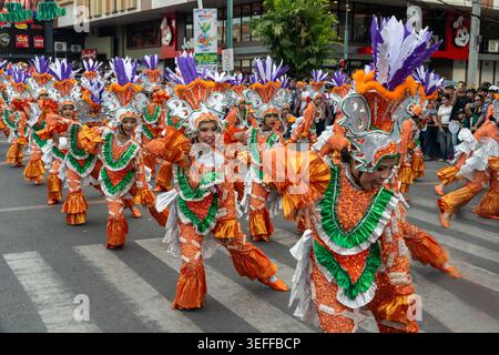 Des danseurs de rue en costumes oranges, verts et argentés ornent la chorégraphie lors du défilé annuel du Saulog Tagbilaran Festival à Tagbila Banque D'Images