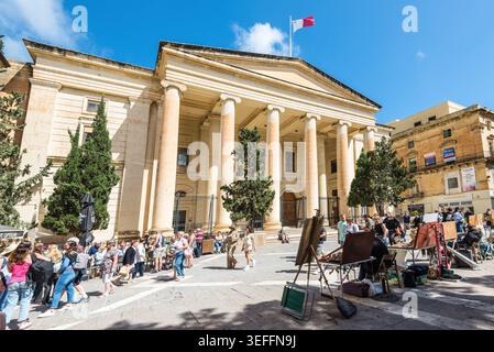 Valletta, Malte – 16 mai 2025 : bâtiment historique des cours de justice sur Republic Street à la Valette, Malte, avec des touristes, des artistes locaux et un bleu ensoleillé Banque D'Images