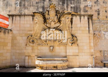 La Valette, Malte – 16 mai 2025 : fontaine de Wignacourt, monument baroque avec des sculptures en pierre ornées et un bec à tête de lion, debout dans le HEA historique Banque D'Images
