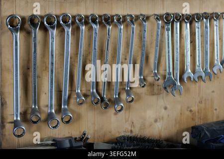 Gros plan de plusieurs clés métalliques soigneusement disposées sur un mur en bois à l'intérieur d'un atelier, montrant les outils, l'artisanat et l'environnement de travail organisé wi Banque D'Images