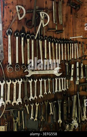 Gros plan de plusieurs clés métalliques soigneusement disposées sur un mur en bois à l'intérieur d'un atelier, montrant les outils, l'artisanat et l'environnement de travail organisé wi Banque D'Images