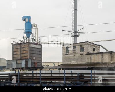 Przemysl, Pologne - 31 mars 2026 : ancienne installation industrielle avec silo métallique et système de tuyauterie de ventilation, illustrant les machines lourdes, logi urbain Banque D'Images
