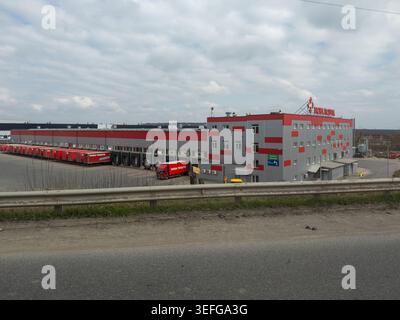 Khmelnytskyi, Ukraine - 30 mars 2026 : bâtiment d'entrepôt Nova Poshta avec plusieurs quais de chargement et des camions de fret rouges, représentant la supp. Mondiale Banque D'Images