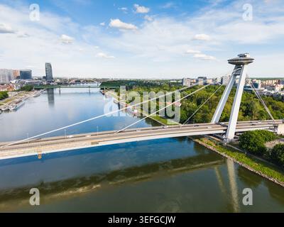 Vue aérienne du pont MOST SNP avec son emblématique pont d'observation des OVNIS enjambant le Danube sous un ciel bleu à Bratislava, région de Bratislava, S. Banque D'Images