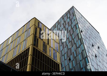 Vue des gratte-ciel modernes avec des façades en verre jaune et bleu sous un ciel couvert à Vienne, Vienne, Autriche. Banque D'Images